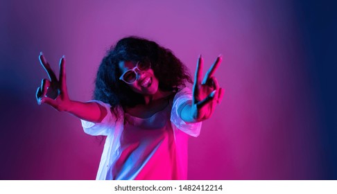 Fashion Young African Girl Black Woman Wear Stylish Pink Glasses Dance Look At Camera Show Peace Gesture Enjoying Festive Party Isolated On Disco Purple Studio Background, Portrait, Copy Space