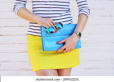 Fashion Young Girl Hold Blue Clutch Handbag And Mirror Sunglasses. Summer Spring Concept Accessories