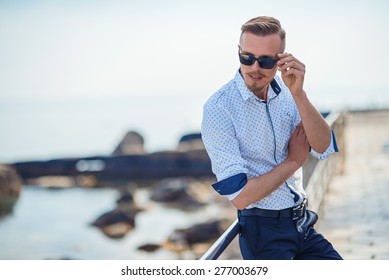 Fashion Young Man Holding His Fashionable Sunglasses Outdoor