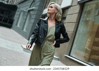 Fashion. Young stylish woman walking on the city street looking aside smiling happy - Shutterstock ID 2345768129