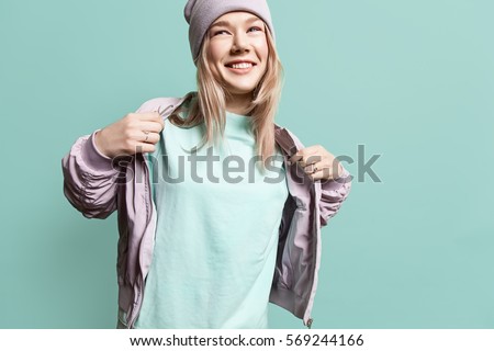Fashion young woman in blank sweatshirt jacket takes on a blue background in pastel colors
