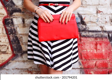 Fashion Young Woman With Red Bag Clutch In Hands And Striped Dress Near Street Wall Closeup