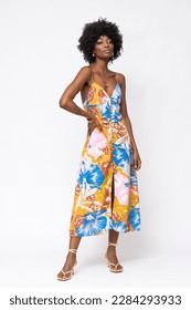 Fashionable African woman with curly hairs and floral dress on isolated white background.