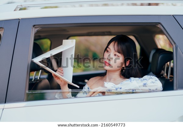 Fashionable Asian girls
make up in the car