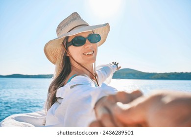 Fashionable beautiful woman relaxing outdoors on the beach on a summer day. I wear a wide-brimmed hat and sunbathe with UV protection. Beach holiday concept. - Powered by Shutterstock