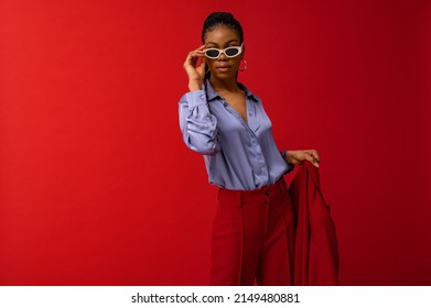 Fashionable Black woman wearing classic red suit, satin blue shirt, trendy sunglasses. Fashion studio portrait. Copy, empty space for text  - Shutterstock ID 2149480881