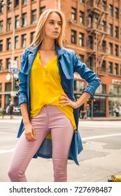 Fashionable Blonde Woman In Jeans Coat And Nice Clothes, Yellow Purse Walking In The Street. Fashion Spring Autumn Photo