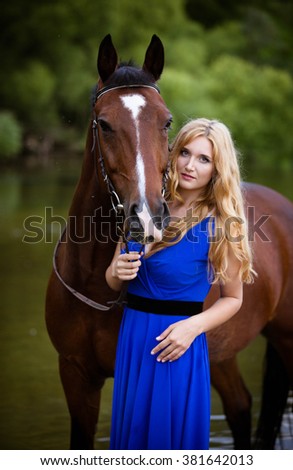 Fashionable blonde woman riding a horse in sunny day.