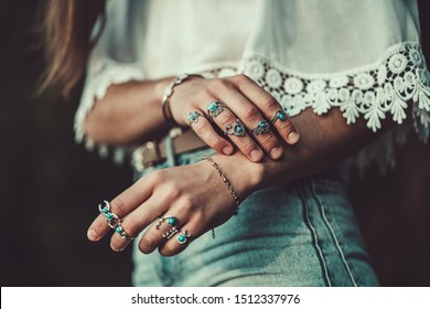 Fashionable boho chic woman in a white short blouse with silver turquoise jewelry. Boho fashion. Stylish girl wearing silver rings with turquoise stone in hippie style.
