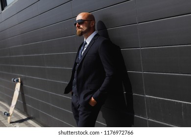 Fashionable business man in perfect suite on the street, using skateboard longboard and sute man - Powered by Shutterstock