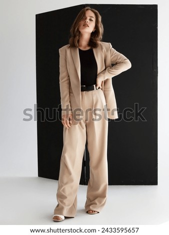 Fashionable confident woman wearing elegant suit with blazer, wide leg trousers. Beautiful brunette woman with natural makeup wear fashion pantsuit. Business meeting
