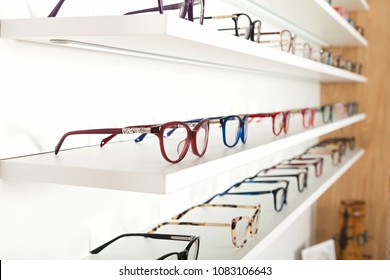 Fashionable corrective eye glasses on a shelf in optical store