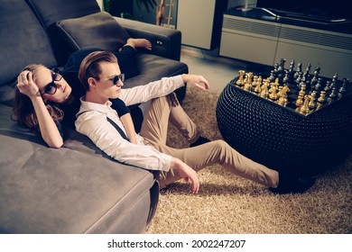 Fashionable Couple In Elegant Clothes And Sunglasses Relaxing In A Luxury Apartment. Fashion Shot. Glamorous Lifestyle. 