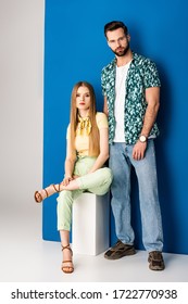 Fashionable Couple Posing In Summer Clothes On Grey And Blue