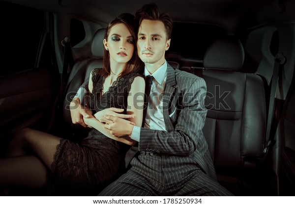 Fashionable couple of young people in the car.\
Glamorous lifestyle, night\
party.