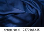 Fashionable dark slate blue luxurious fabric. Navi blue elegant textile folds. Silk slate blue color bedsheets material.