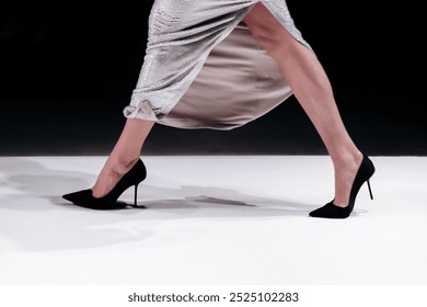 Fashionable details of a long flowing shiny skirt and black high heels - Powered by Shutterstock