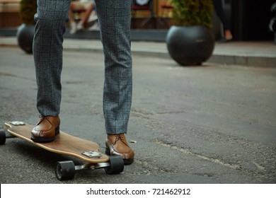 Fashionable European Business Man In Perfect Suite Walk On The Street, Using Skateboard Longboard And Sute Man