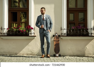 Fashionable European Business Man In Perfect Suite Walk On The Street, Using Skateboard Longboard And Sute Man