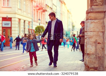 fashionable father and son walking in old city street