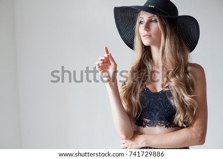 fashionable girl in a hat with a brim poses for advertising
