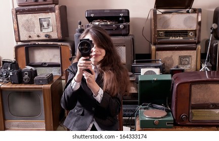 Fashionable Girl In Pin Striped Suit Sat On Wooden Chair In Antique Shop. 