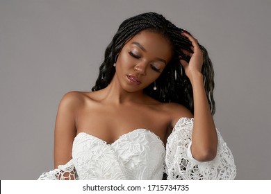 Fashionable Girl Wearing Casual White Top And Blue Jeans. Young African Woman, Female Model With Long Black African Pigtails Hair And Perfect Makeup. Studio Shot At Gray Background