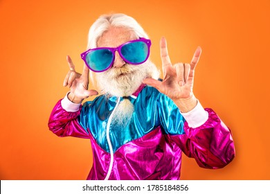 Fashionable grandfather posing with funny futuristic clothes. Senior man portraits on colored background