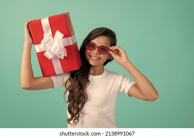 fashionable happy teen girl in sunglasses hold gift box, bday
