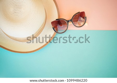 Fashionable hat and sunglasses on a multi-colored background.