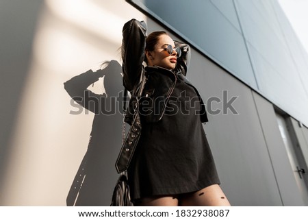 Woman in sensual dress dancing shy from urban stairs