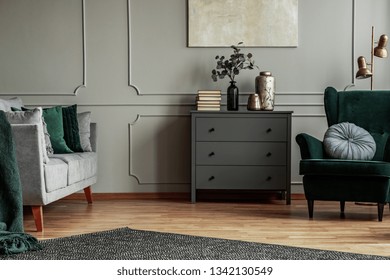 Fashionable living room interior with wooden commode, scandinavian sofa and emerald green armchair - Shutterstock ID 1342130549