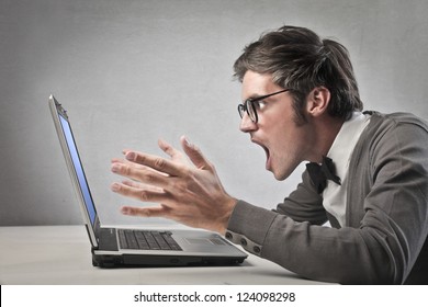 Fashionable Man Screaming Against A Laptop Computer