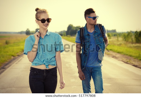 Fashionable models wearing jeans clothes posing on a\
highway. Denim style.\
