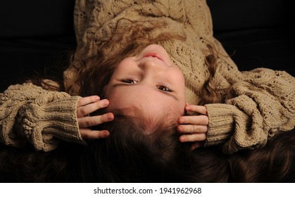 
Fashionable Portrait Of A Girl 5 Years Old In A Knitted Sweater On A Black Background