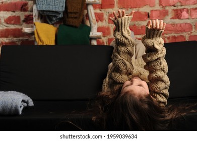 Fashionable Portrait Of A Girl 5 Years Old In A Knitted Sweater On A Black Background