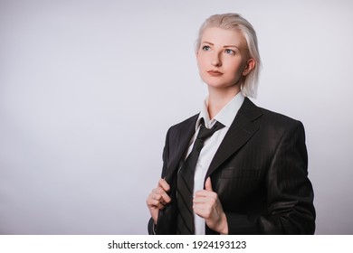 Fashionable portrait of a woman dressed in men's clothing. Girl in a white shirt, jacket and tie on a white background. The idea of a strong woman as a man. photo in studio