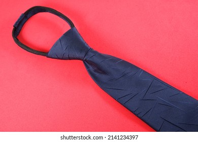 Fashionable Pre Tied Zipper Neck Tie Isolated On Plain Color Background, Zipper Type Necktie On A Red Surface With Top Angle View