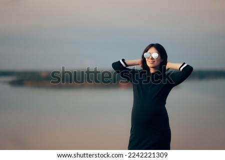 Similar – Blonde woman with black dress and sunglasses performing dance in nature with backlight