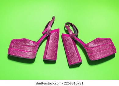 Fashionable punk square toe ankle strap pumps on green background, flat lay. Shiny party platform high heeled shoes
