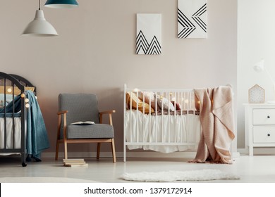 Fashionable Retro Armchair Between Two Wooden Cribs In Cute Twins Nursery