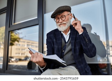 A fashionable senior man with a beard sketches thoughtfully, wrapped in the colors of autumn by a chic building. - Powered by Shutterstock