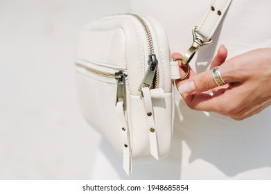 Fashionable shoulder leather white bag close up. Selective focus on details.