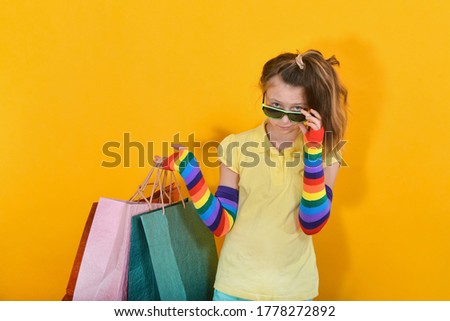 Fashionable and stylish girl in sunglasses holds shopping bags in her hands
