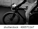 Fashionable urban dweller on fixed-gear bicycle at night. Black and white lifestyle