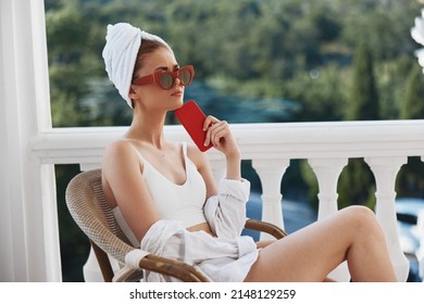 Fashionable Woman Enjoying The Morning On The Balcony Looking At The Mobile Phone Screen Unaltered