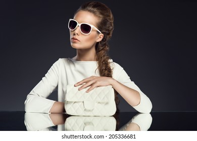 Fashionable Woman With Handbag And Sunglasses Wearing All White Posing At The Mirror