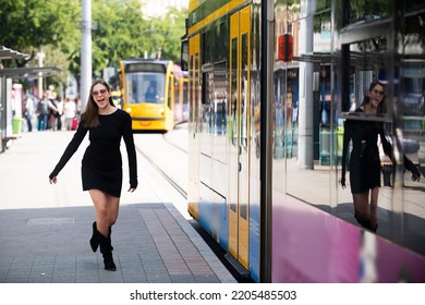 Fashionable Woman Running After Bus Trolleybus And Pulling Trolley Case On The Street, Fashion Street Style.