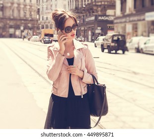 Fashionable Woman Talking On The Phone While Walking