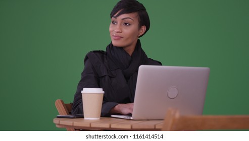 Fashionable Woman Using Laptop Computer At A Cafe Table On Green Screen